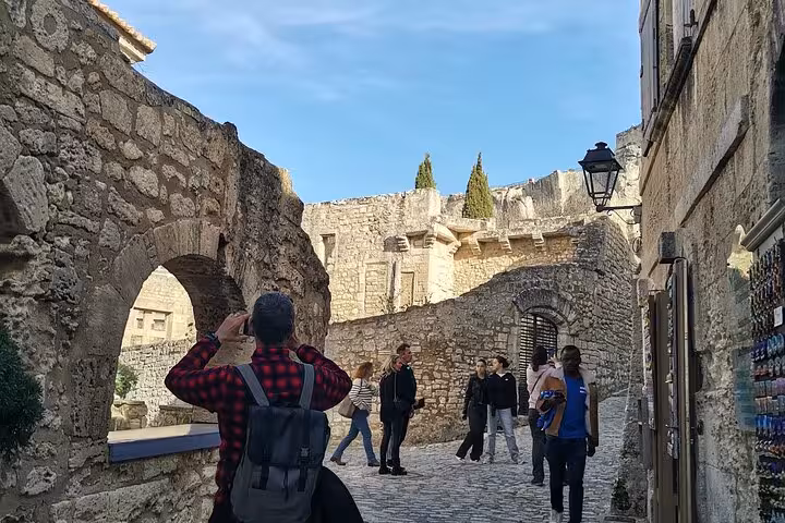 Visitors exploring medieval ramparts in Les Baux-de-Provence, guided culture and landscapes tour near Saint Rémy