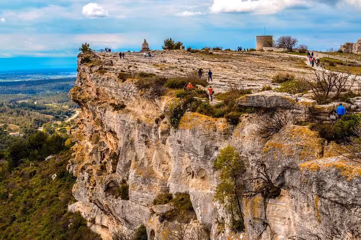 Panoramic cliffs of Les Baux-de-Provence with hikers and views over Alpilles, Saint Rémy culture landscapes tour