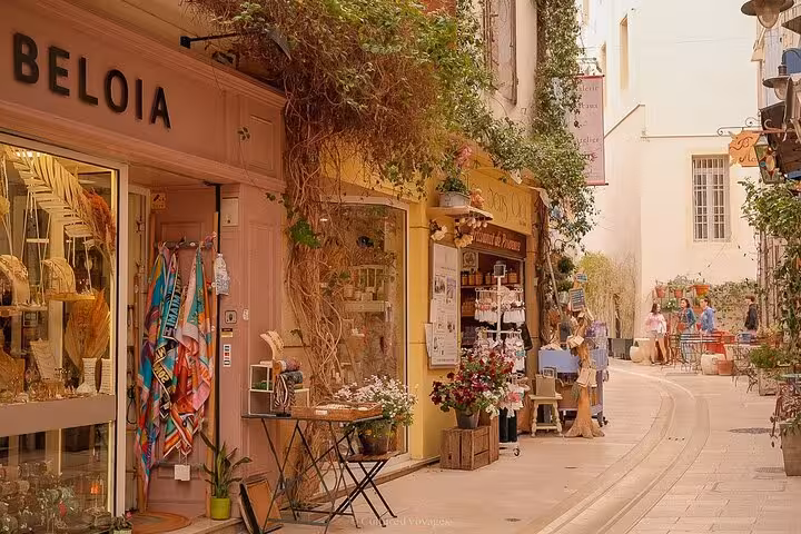 Charming street in Les Baux de Provence with quaint shops and colorful displays on a sunny day.