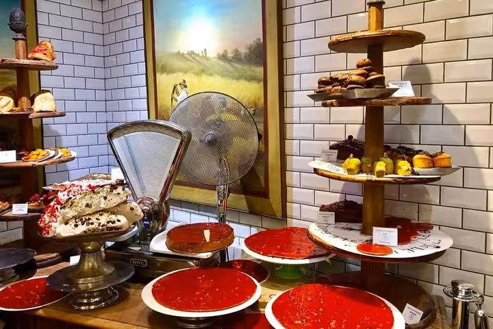Assortment of colorful pastries and desserts displayed in a bakery at Les Halles Paul Bocuse market.