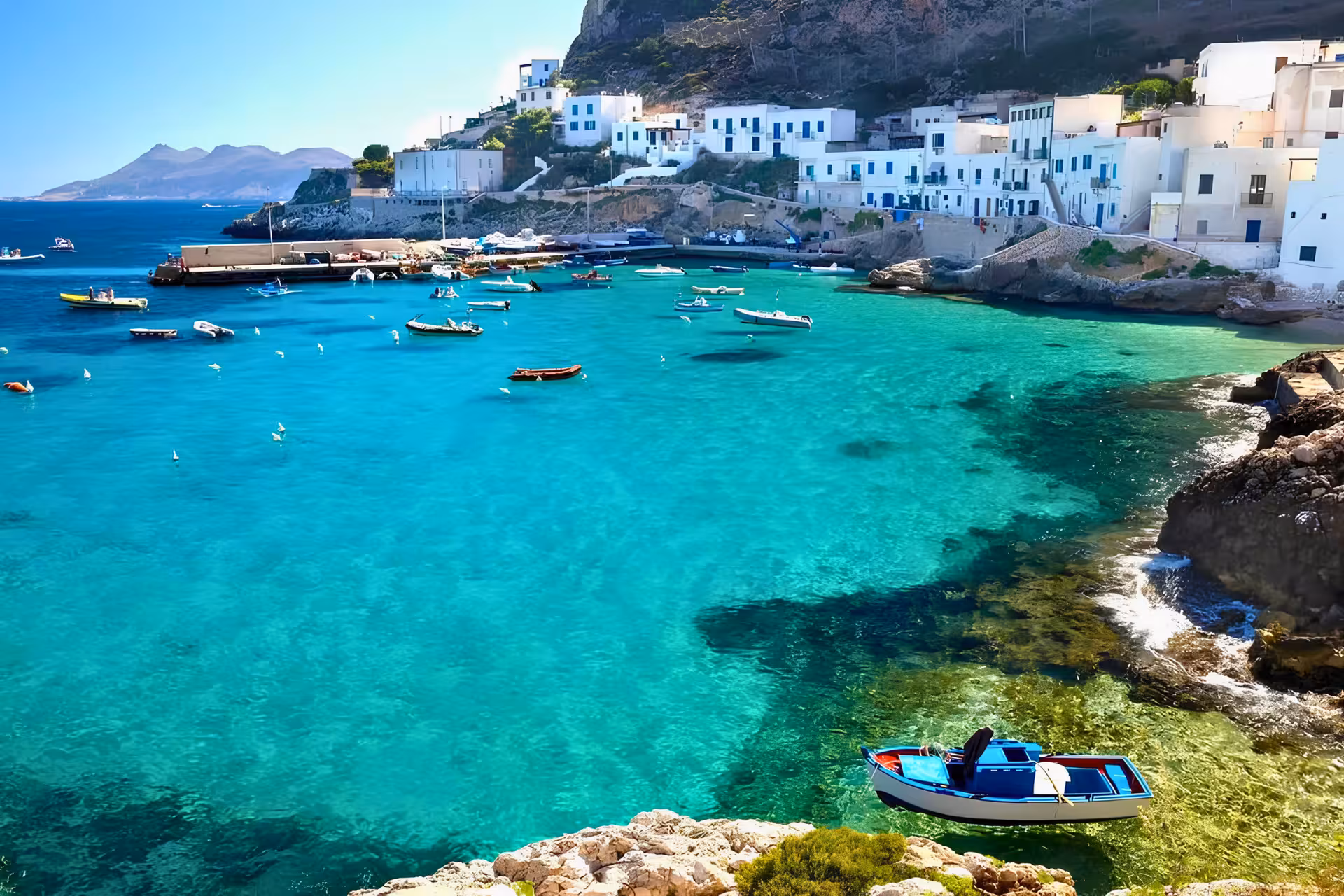 Levanzo harbor with white village and anchored boats, Egadi Islands private boat tour from Trapani with lunch included