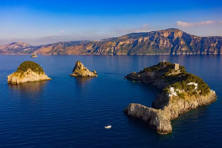 Scenic view of the Li Galli Islands surrounded by turquoise waters with distant mountains near Amalfi, Italy.