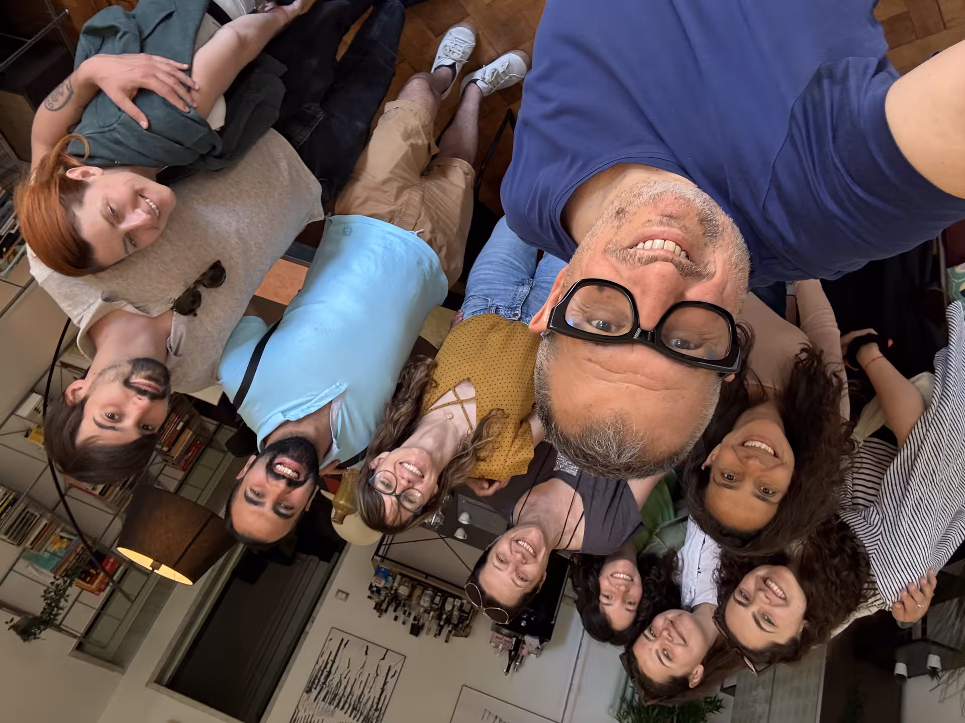Smiling group enjoying Ligurian cooking class in a cozy kitchen setting.