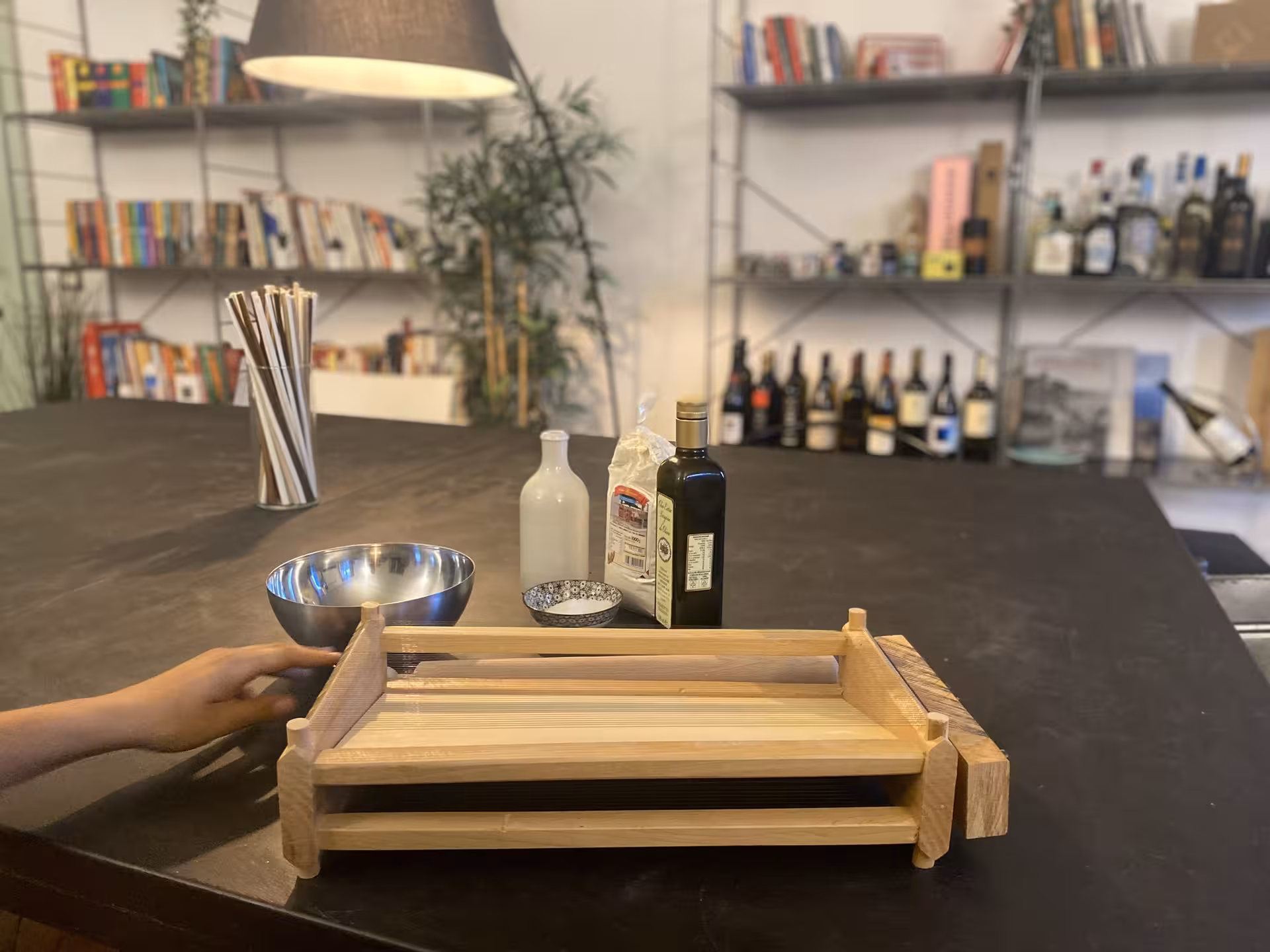 Ingredients for Ligurian focaccia arranged on a table, including olive oil and flour, in a cozy kitchen setting.