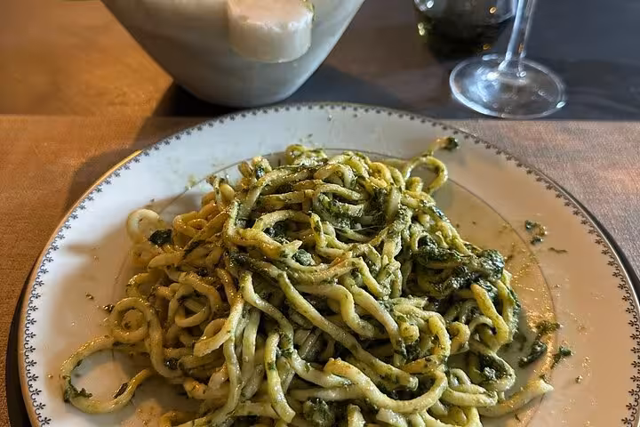 Plate of traditional Ligurian pasta with pesto served on a dining table in Chiavari's historic center.
