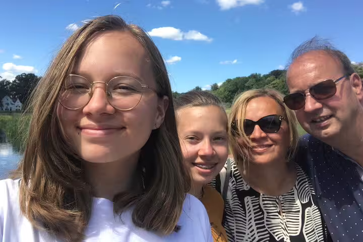 Group selfie outdoors in Lille on a self-guided e-scavenger hunt, solving riddles and sightseeing