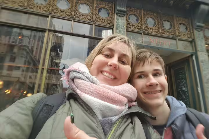 Happy travelers selfie by ornate Lille Old Town storefront on a Lille scavenger hunt walking tour