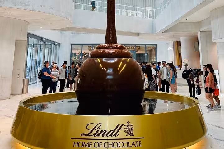 Lindt Home of Chocolate Museum Zurich giant chocolate fountain, visitors on guided tour with pickup