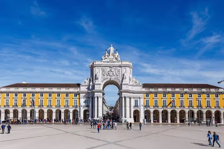 People gather under the iconic Arco da Rua Augusta in Lisbon's vibrant Old Town, a highlight of the full-day small-group tour.