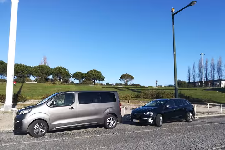 Comfortable Lisboa to Porto transfer vans parked on a sunny day, ideal for group travel and sightseeing.