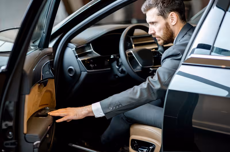 Professional driver in suit preparing vehicle for private Lisbon airport to hotel transfer.