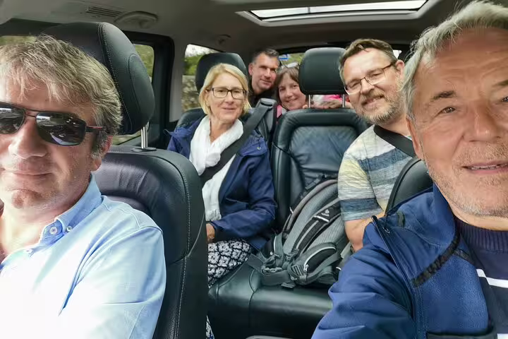 Group of cheerful passengers enjoying a comfortable ride in a Lisbon airport shuttle, perfect for seamless travel connections.