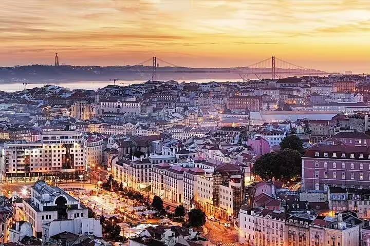 Scenic view of Lisbon at sunset highlighting vibrant cityscape and iconic bridge, perfect for private airport transfer listings.