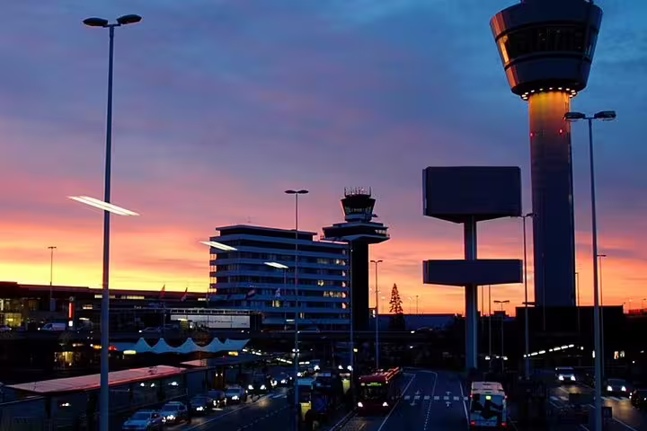 Lisbon airport transfer service with scenic sunset view of control tower and terminals, offering seamless travel experience.