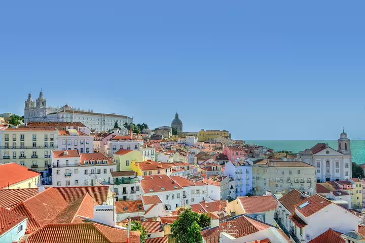 Scenic view of Lisbon's historic Alfama district with vibrant rooftops, ideal for a food and walking tour experience.