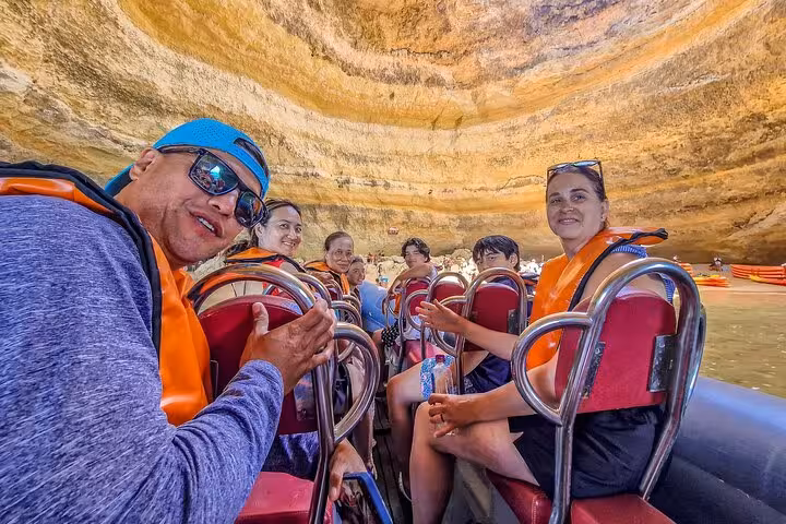 Smiling group on boat in Benagil Sea Cave, Algarve experience on all-inclusive private tour from Lisbon