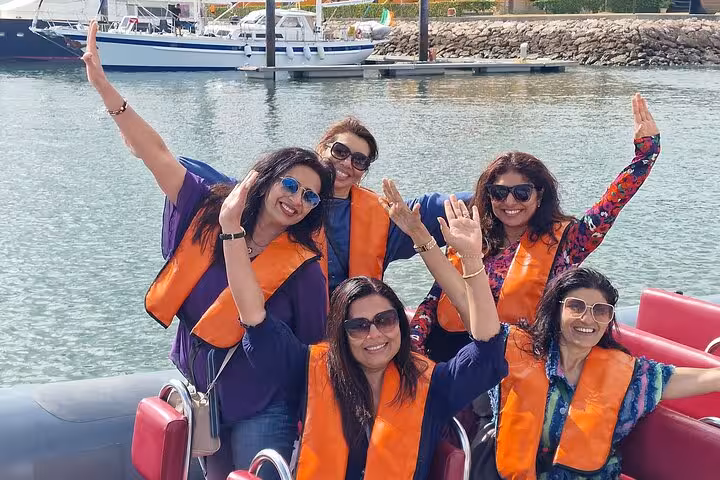 Friends waving on speedboat at Algarve marina before Benagil Cave, all-inclusive private Lisbon to Algarve tour