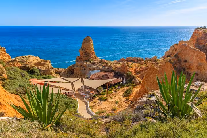 Scenic Algarve coastline view with rocky cliffs and blue ocean, ideal for a Lisbon to Algarve Mercedes transfer tour.