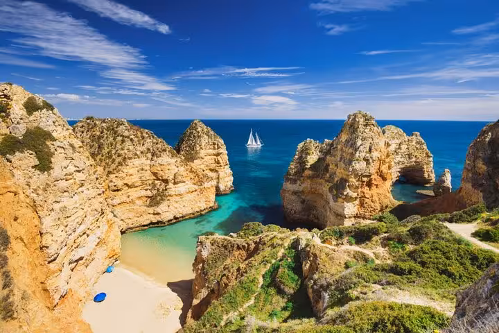 Scenic Algarve cliffs and turquoise waters viewed during Lisbon to Algarve private Mercedes transfer tour.