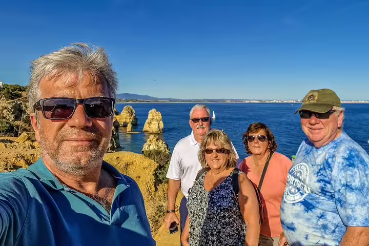 Group enjoying scenic Algarve coast on a sunny day during a 2-day private tour from Lisbon with stunning ocean views.