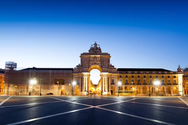 Lisbon's iconic Arco da Rua Augusta illuminated at dusk, a highlight of the full-day private tour in a premium vehicle with custom stops.