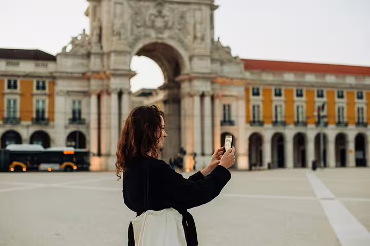 A tourist captures the iconic Arco da Rua Augusta in Lisbon, a must-see on the Lisbon Highlights for Newcomers Private Tour.