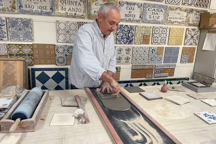 Artisan crafting traditional tiles during the Setúbal & Arrábida wine tour with lunch, showcasing Portuguese culture.