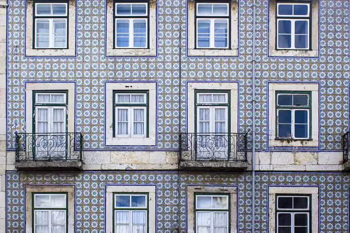 Colorful azulejo tiles adorn a traditional Lisbon building facade, showcasing local architecture on a private city tour.