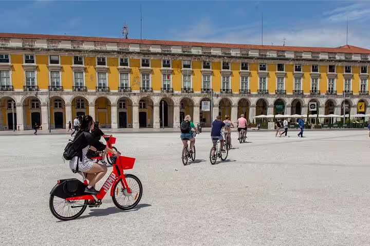 Cyclists enjoy a sunny day touring Lisbon's historic Praça do Comércio on a private bike tour showcasing Lisbon and Belém highlights.