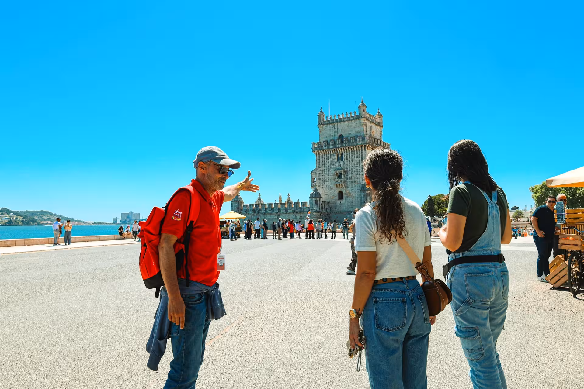 Tour guide explaining the history of the Belém Tower to visitors, showcasing Lisbon's rich cultural heritage and landmarks.