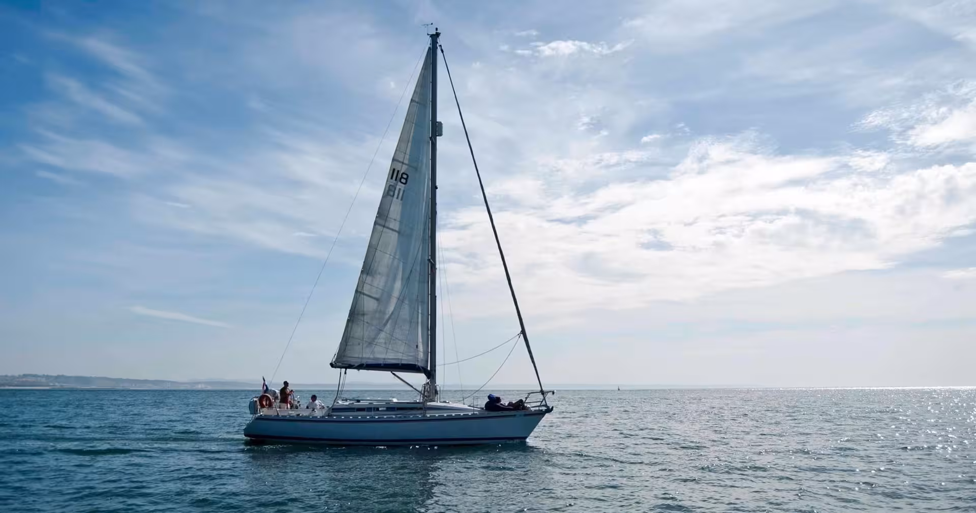 Sailboat cruising on calm sea under blue sky, perfect boat sailing add-on for a guided bike tour experience