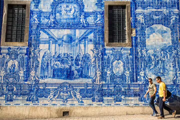 Tourists admire intricate blue azulejos on a historic Lisbon wall during a private walking tour exploring the city's art secrets.