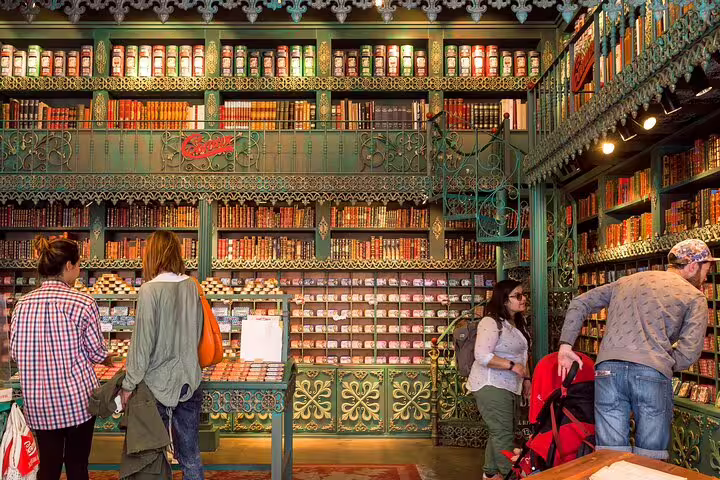 Tourists explore a colorful, ornate shop filled with canned goods on a food and drink tour in Lisbon and Cacilhas.