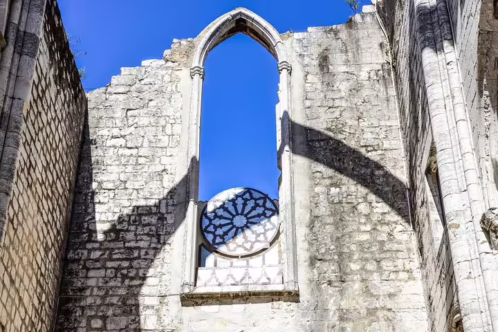 Historic Carmo Convent ruins under a clear blue sky, a highlight of the Lisbon private walking tour, showcasing Gothic architecture.