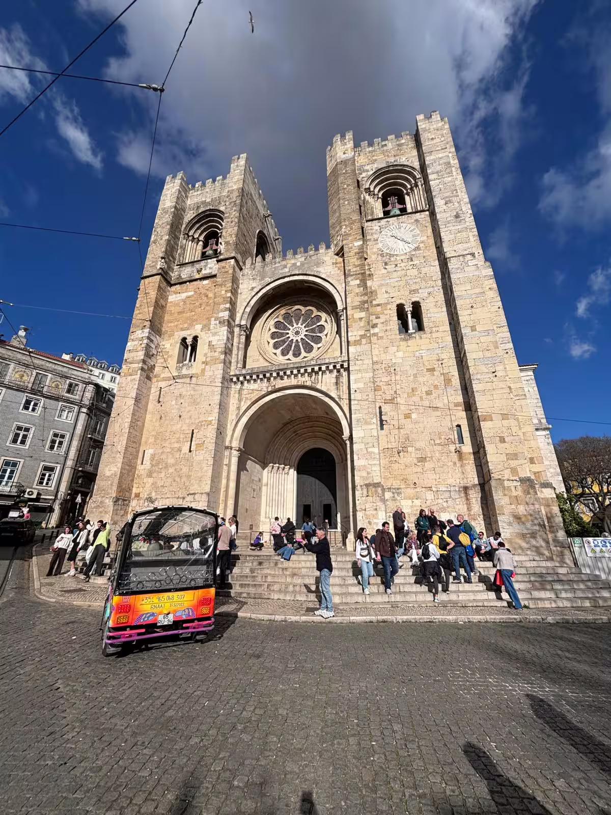Tourists gather outside Lisbon's iconic cathedral, a popular starting point for cultural tours.