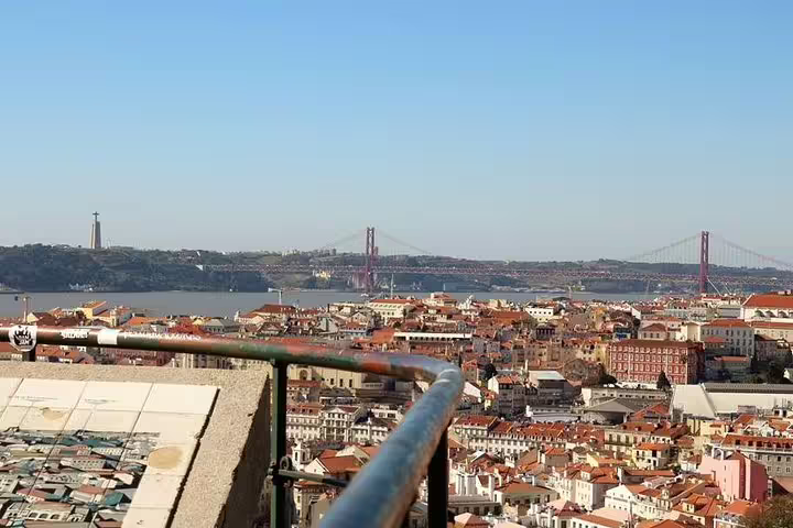 Panoramic view of Lisbon cityscape with iconic 25 de Abril Bridge and Cristo Rei statue, perfect for a private customizable tour.