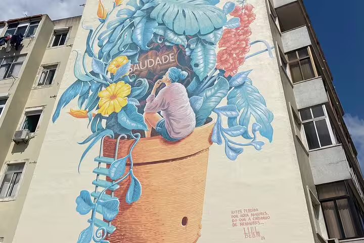 Colorful Lisbon mural featuring a person surrounded by lush foliage, symbolizing the Portuguese concept of saudade.