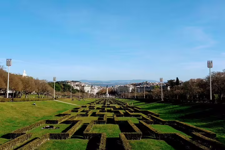Aerial view of Lisbon's Eduardo VII Park with lush greenery and cityscape backdrop, featured in the Lisbon World Heritage Deluxe Tour.