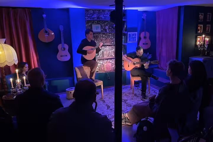 Intimate Lisbon Fado concert with musicians playing guitars under candlelight, creating a cozy cultural experience.