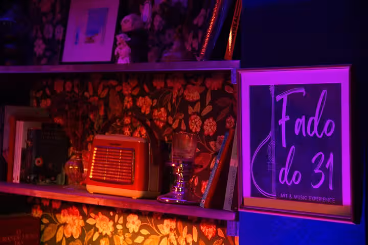 Cozy Lisbon venue with Fado do 31 sign, vintage decor, and books, enhancing the authentic Fado concert ambiance.