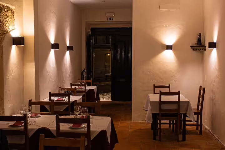 Intimate dining area in Lisbon, featuring candlelit tables set for a memorable Fado music dinner show.