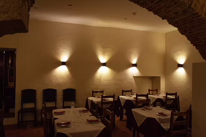Elegant dining room set for a Lisbon Fado dinner show, featuring warm lighting and neatly arranged tables.