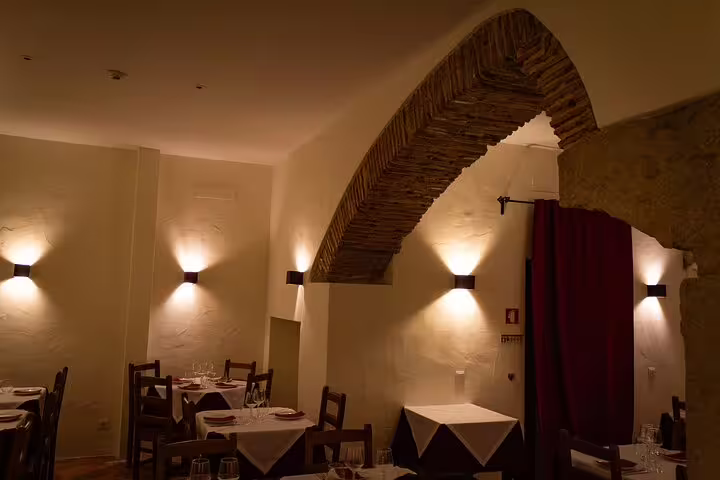 Charming dining area in Lisbon with elegant lighting and brick archways, perfect for a Fado music evening.
