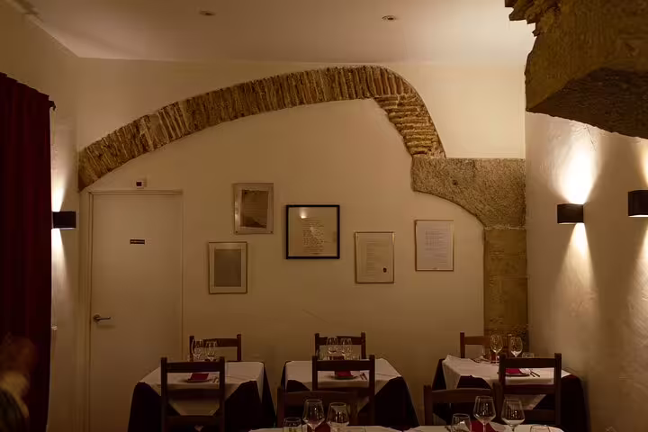 Rustic Lisbon dining room with stone accents and tables set for a Fado dinner with rising stars of Fado music.