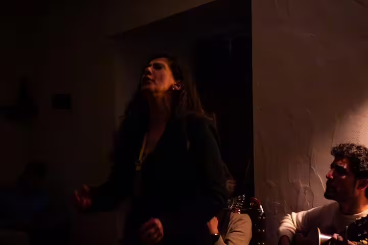 Fado singer passionately performing with guitarist in a cozy Lisbon venue during a dinner show experience.