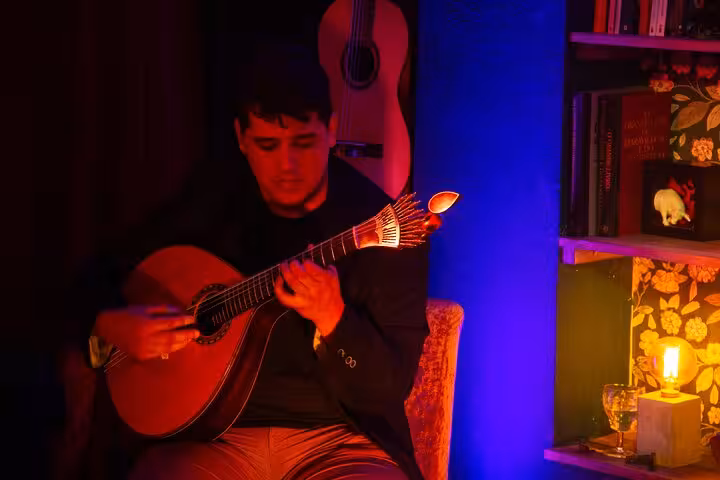 Solo musician passionately plays Fado guitar in a dimly lit, atmospheric Lisbon setting.