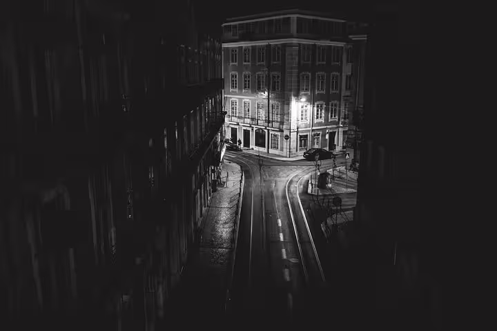 Nighttime view of a quiet Lisbon street, setting the mood for a private Fado tour with illuminated historic architecture.