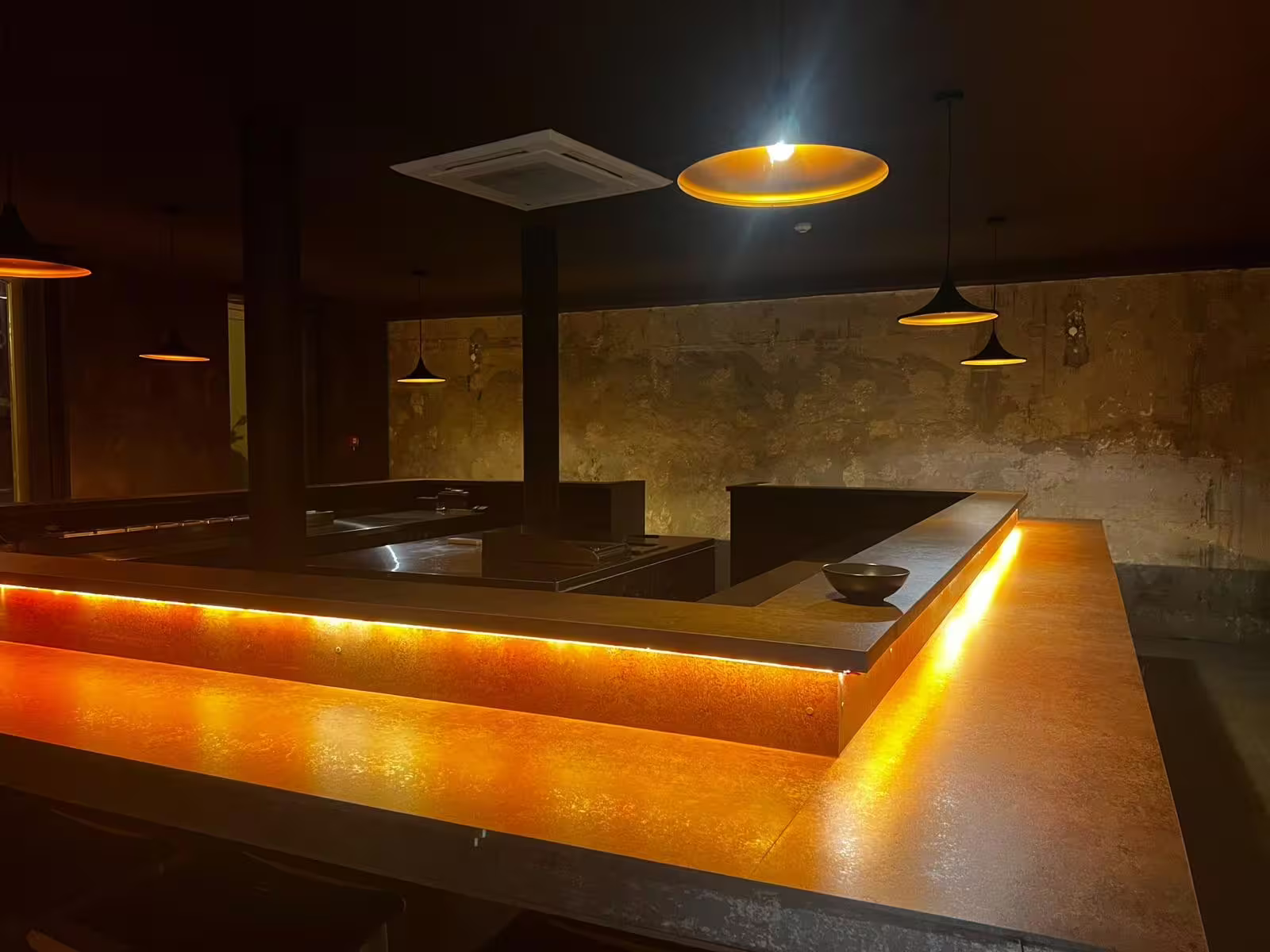 Cozy Fado venue with dim lighting and elegant amber accents, perfect for an intimate live music experience.