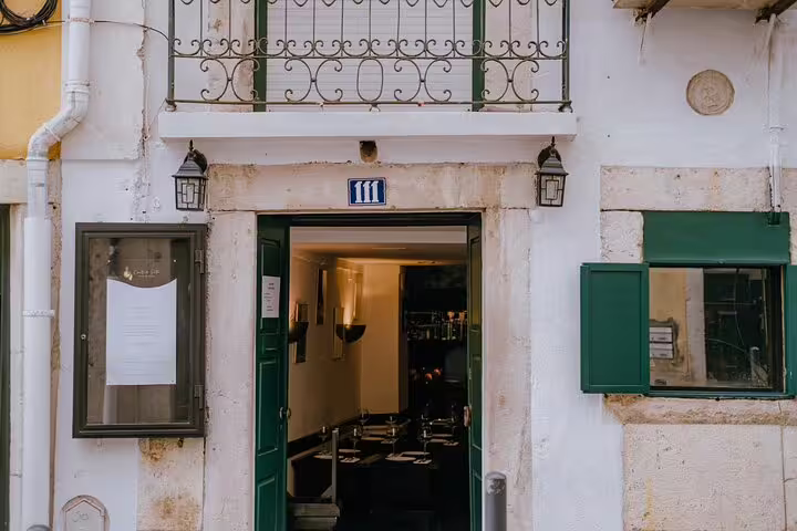 Charming Lisbon fado venue exterior with open door inviting visitors to experience traditional Portuguese music inside.