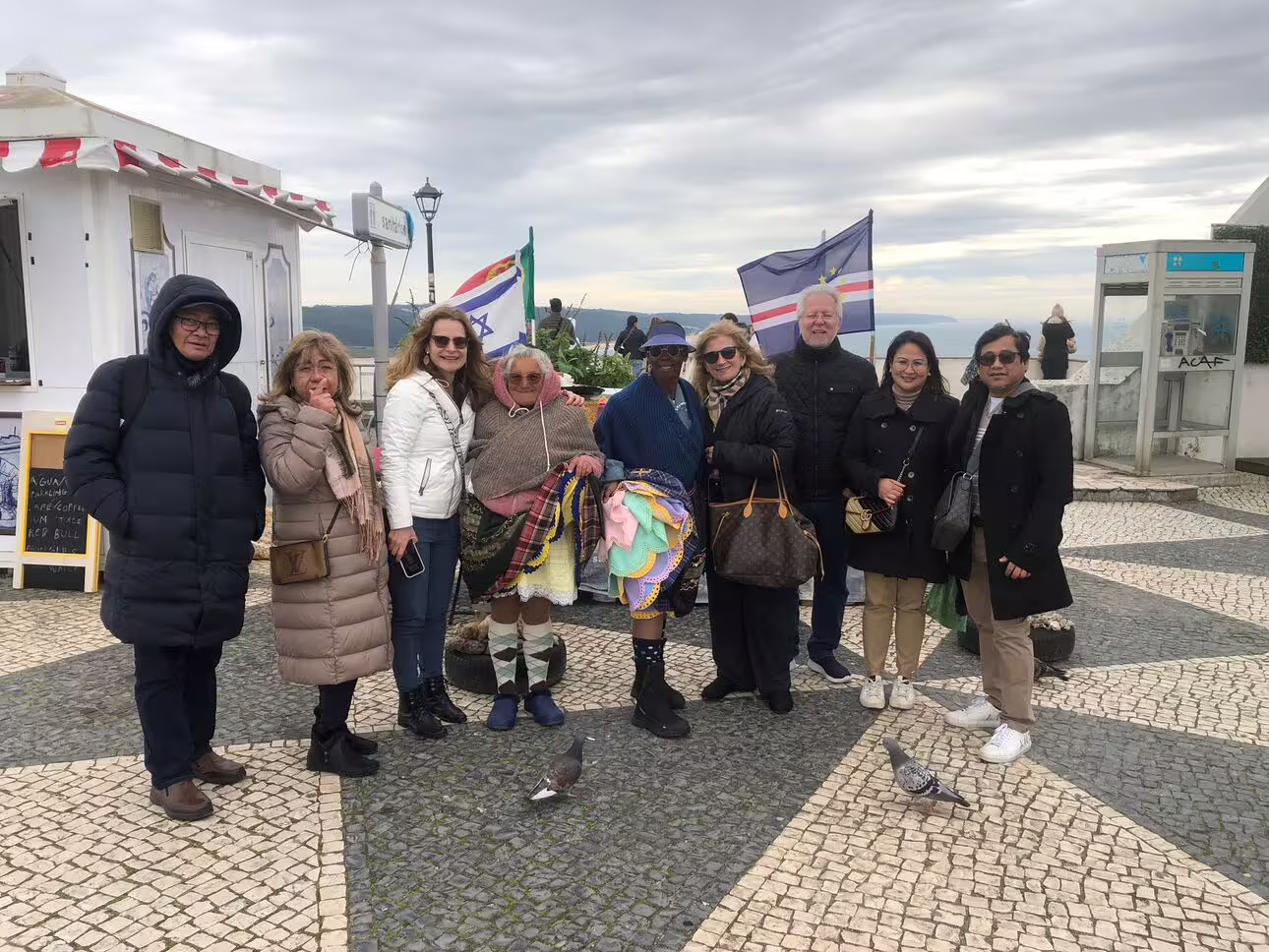 Travelers gather at a scenic viewpoint in Nazaré during the Fátima, Nazaré, Batalha, and Óbidos guided tour.